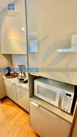 A kitchen with a microwave, a blender, and a coffee maker on the counter. - La Fleur Collection Vacation Homes (Ipojuca)