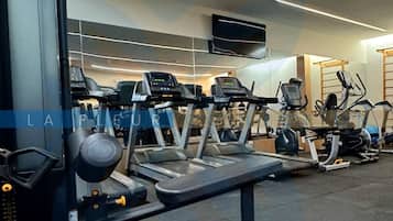 Uma academia com esteiras, elípticos e equipamentos de musculação.