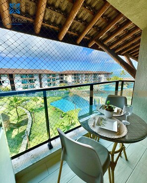 Un balcon donnant sur une piscine et un bâtiment d’hôtel.