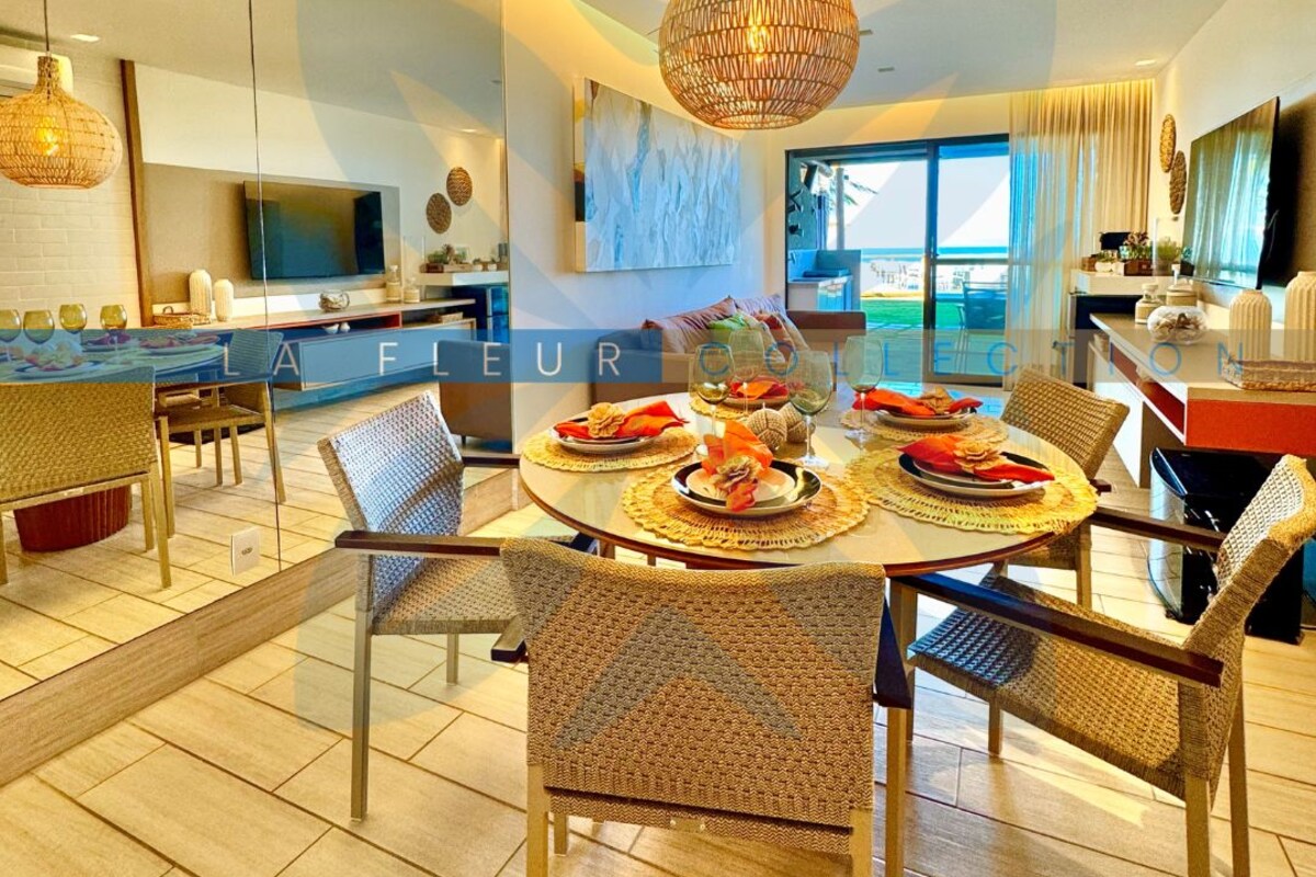 A modern dining area with a round table, wicker chairs, and a hanging light fixture.