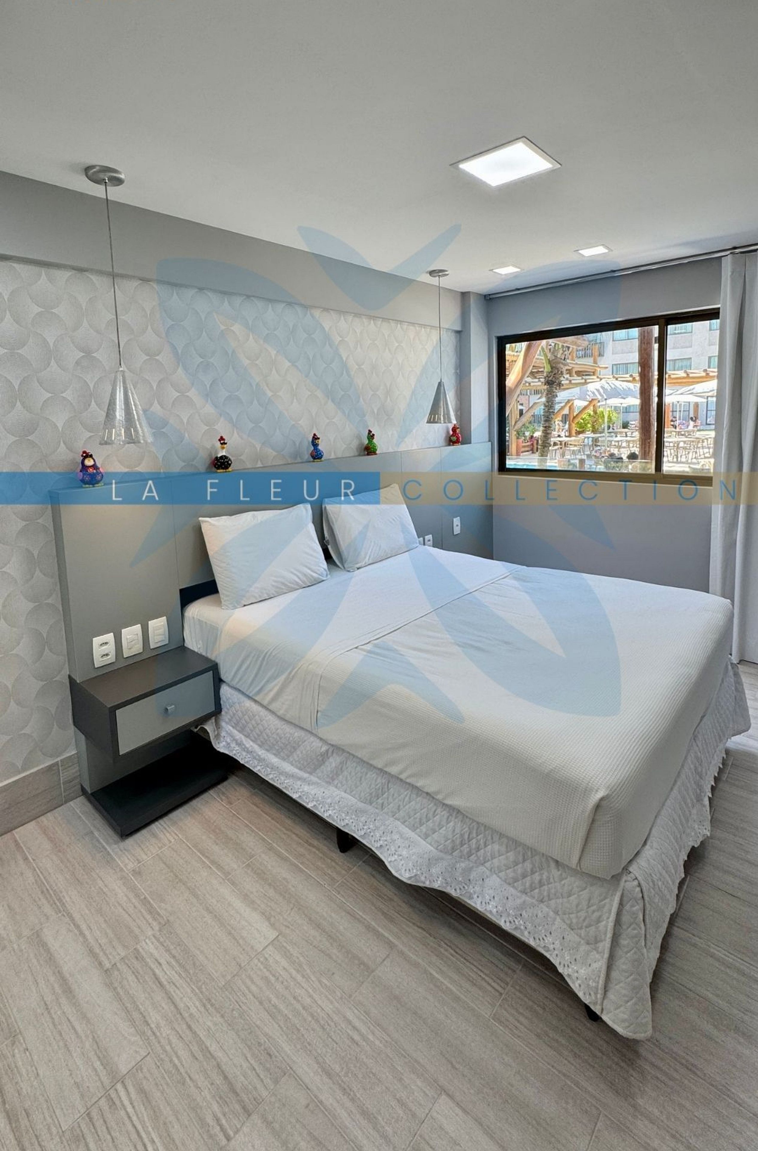A modern bedroom with a bed, bedside tables, and a window with a view.