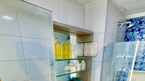 A modern bathroom with a glass shower enclosure, a white toilet, and a vanity with a sink and mirror. - La Fleur Collection Vacation Homes (Ipojuca)