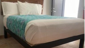 A bed with a wooden headboard, a teal and white bedspread, and a beige blanket. - Spanish Moon PV - # 9 Queen Room, refrig. , micro.,coffee maker, pool, WiFi, TV (Puerto Vallarta)