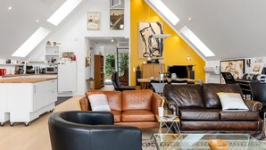 Moderni loft-tyylinen asunto, jossa on keittiö, ruokailutila ja olohuone.