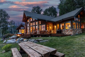 A log cabin with a stone exterior, large windows, and a wooden deck. - Telluride Modern Estate | Panoramic Mountain Views (Telluride)