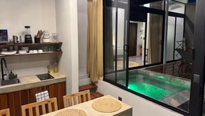 Une cuisine moderne avec un coin repas et une grande fenêtre donnant sur une piscine.