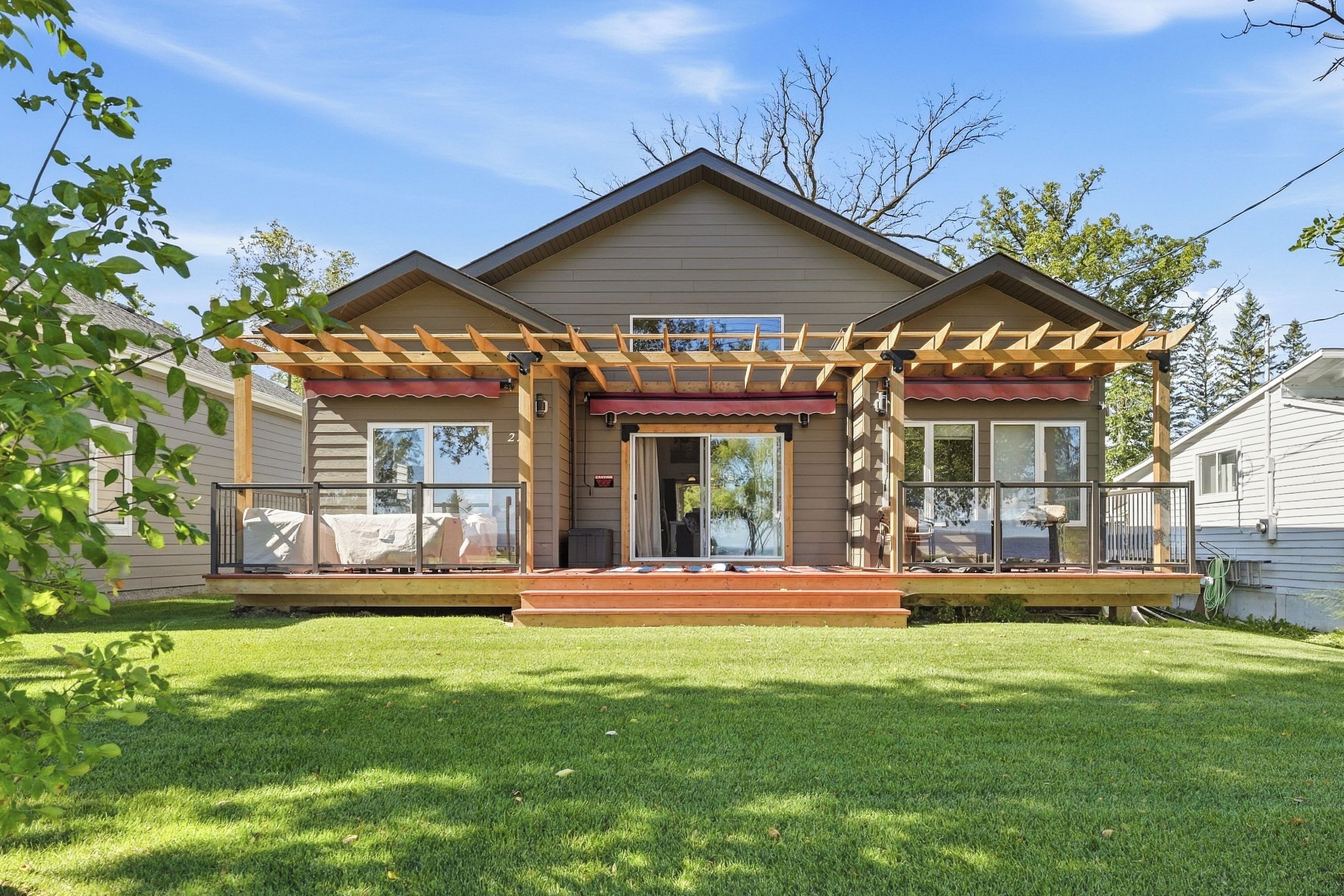 A two-story house with a covered porch, large windows, and a well-maintained lawn.