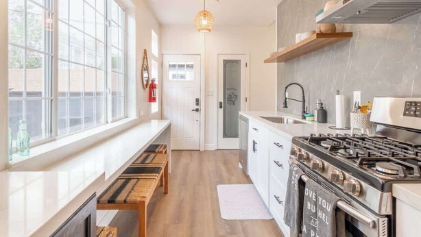 A modern kitchen with a large window, a gas stove, and a built-in oven. - Stylish 2-bedroom Walking Distance to Downtown (Reno)