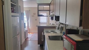 Una cocina con estufa, microondas y refrigerador.