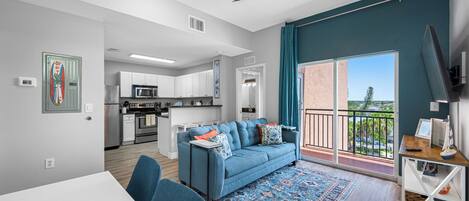 A modern apartment with a dining area, kitchen, and balcony.
