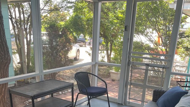 Un'area patio coperta con un divano, un tavolo e una sedia.