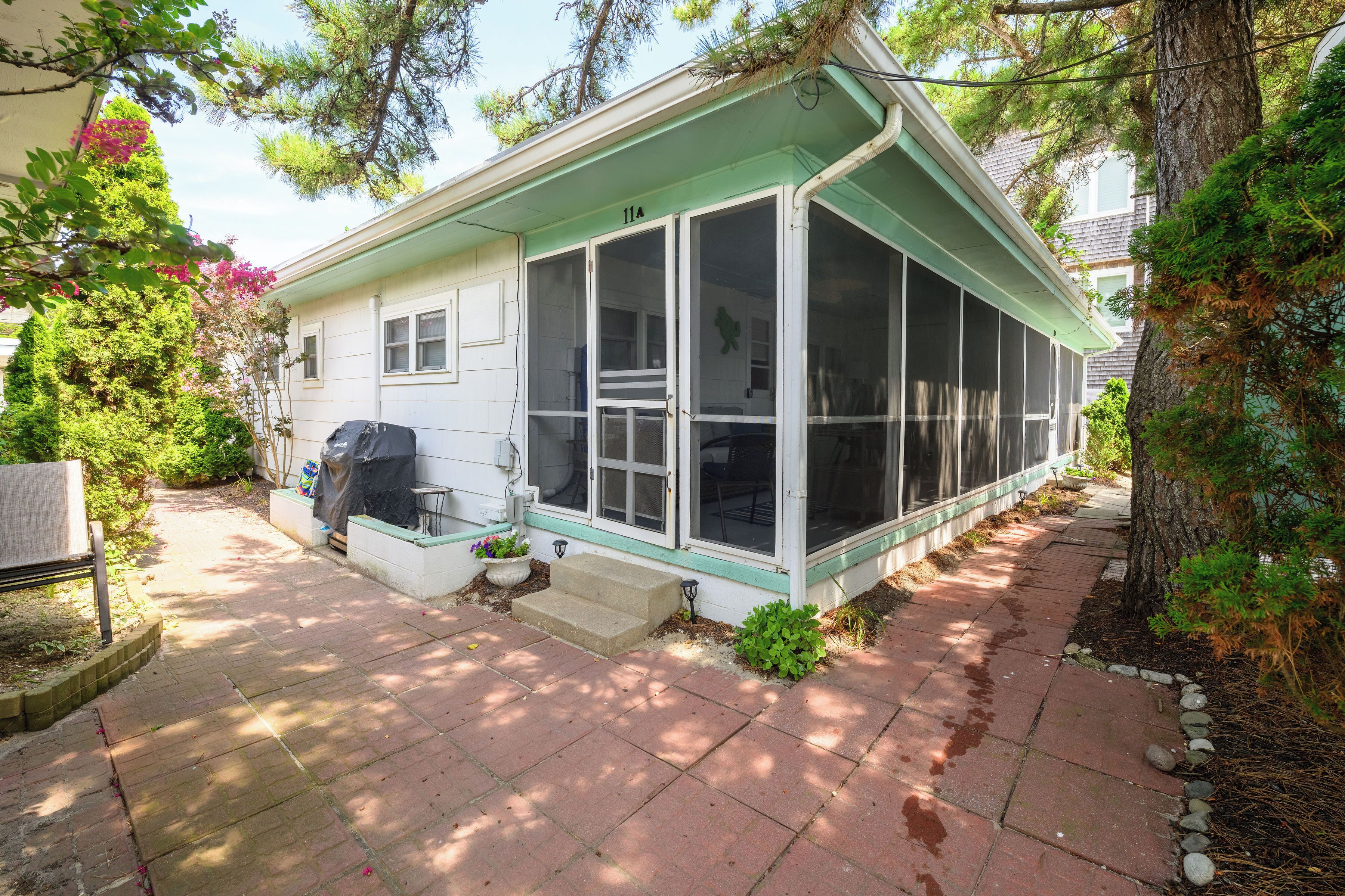 A single-story house with a covered porch, a small front yard, and a mailbox.