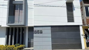 A modern building with a garage door, a balcony, and a clear sky.