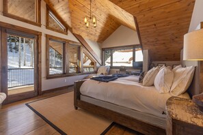 A bedroom with a wooden ceiling, large windows, a bed, and a nightstand. - Apex - Walk to Trails + Hot Tub | Sauna & Theater (Mountain Village)