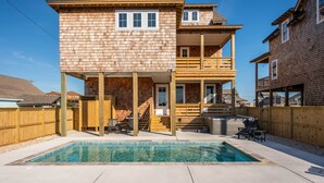 A two-story wooden house with a swimming pool, outdoor seating, and a wooden deck. - Nags Head 369: New Construction, Private Pool, Hot Tub, Ocean Views! (Nags Head)