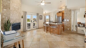 A spacious kitchen with a large island, a ceiling fan, and a view to the outdoors. - Heated Pool, Waterslide, Mountain Views 3 Bedroom 2 Bathroom Tuscan Home (Fountain Hills)