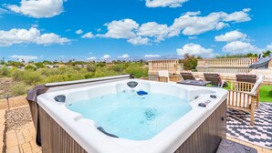 A hot tub with a view of a mountainous landscape and a patio area with outdoor furniture. - Heated Pool, Waterslide, Mountain Views 3 Bedroom 2 Bathroom Tuscan Home (Fountain Hills)