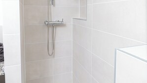 Een douche met een handdouche en een wandmengkraan.