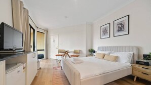 Una habitación de hotel moderna con una cama grande, un escritorio y una televisión.