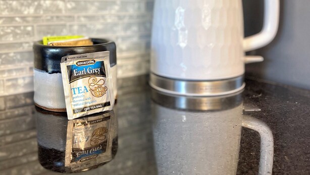 A stainless steel mug and a tea bag on a reflective countertop. - NEW! Private Wooded Escape Between 2 Lakes • Walk to 1 • BYO Boat • Pet-friendly (Austin)