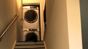 Een trap die leidt naar een wasserette met twee wasmachines.