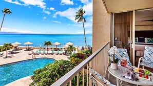 A balcony with a pool, lounge chairs, and a view of the ocean.