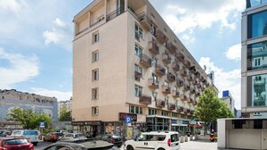 A multi-story building with balconies, a parking sign, and a storefront with a sign that reads "DARINA PL."