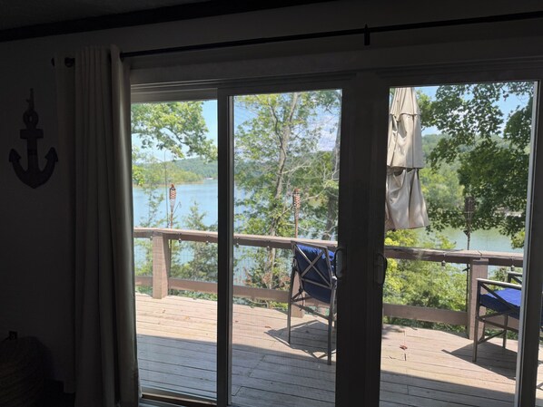 A room with a view of a wooden deck and a lake. - The Lakeview Cabin (Clarkson)