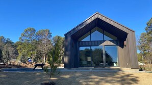 A modern building with a triangular roof and large glass windows. - Charming 2-bedroom, lakeside cabin at Lake Cypress Springs in Mt. Vernon, TX (Mount Vernon)