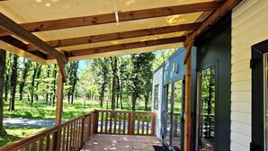 Una terraza cubierta de madera con vista a un área boscosa.