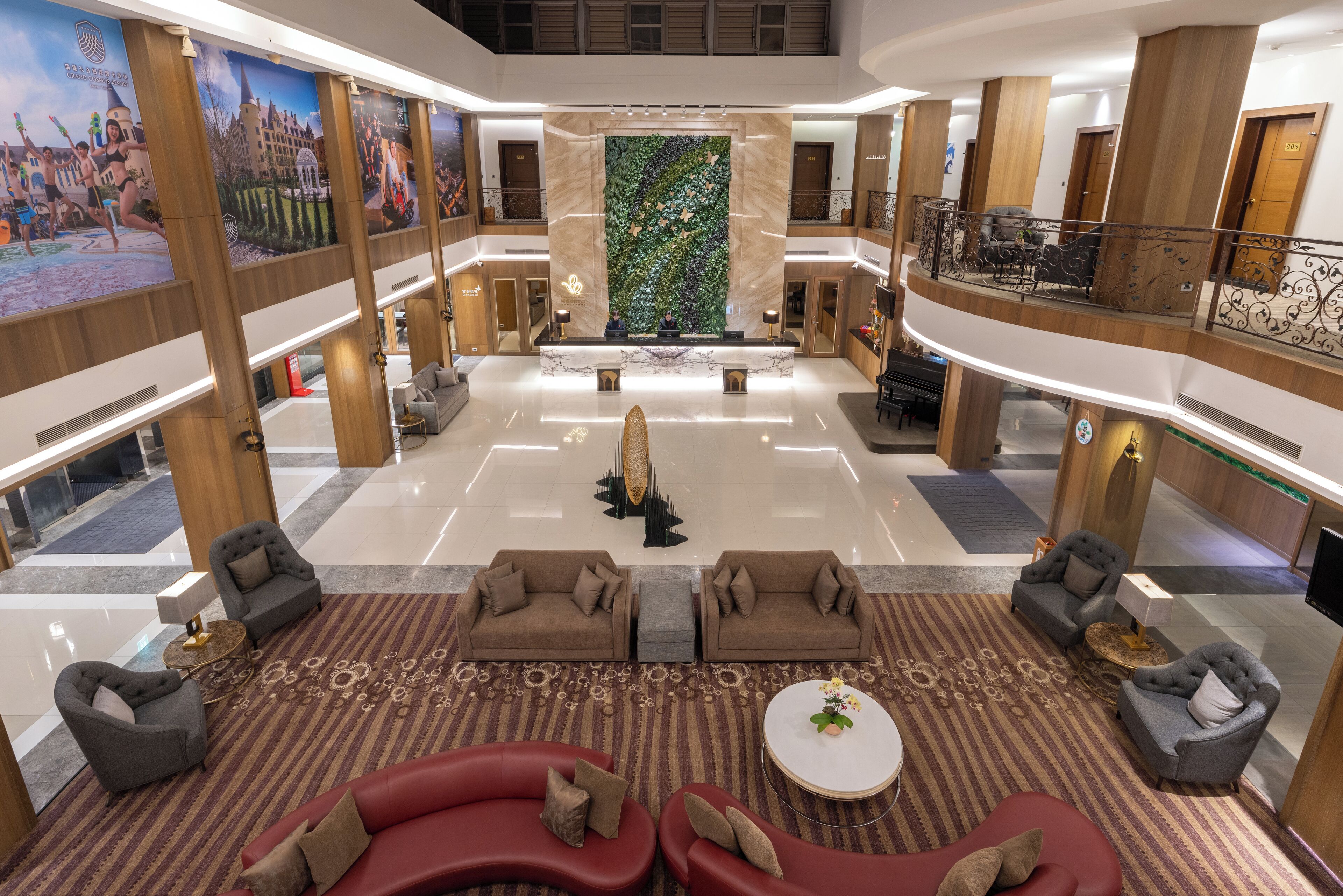 A spacious lobby with a central seating area, a large decorative wall, and a balcony with seating.