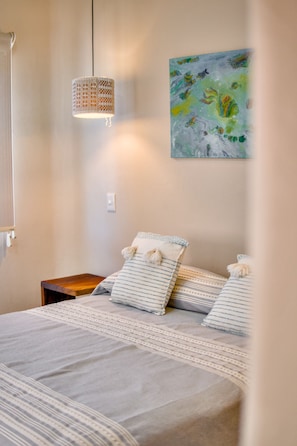 A bedroom with a bed, a hanging light fixture, a painting, and a nightstand. - Delightful apartment with AC in Lo de Marcos (Lo de Marcos)