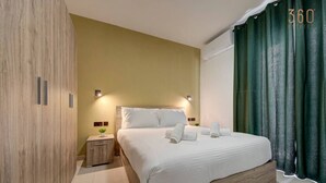 Ein modernes Hotelzimmer mit einem Bettgestell aus Holz, einem Nachttisch mit Lampe und einem grünen Vorhang.