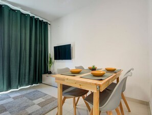 Un coin repas avec une table en bois, quatre chaises et quatre bols.