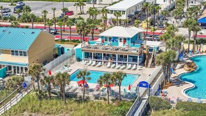 Un hôtel doté d’une piscine, d’un espace détente couvert et d’un bâtiment avec un toit bleu.