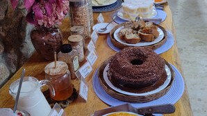 Una mesa de buffet con diversos alimentos, entre ellos pasteles, frutas y bebidas.
