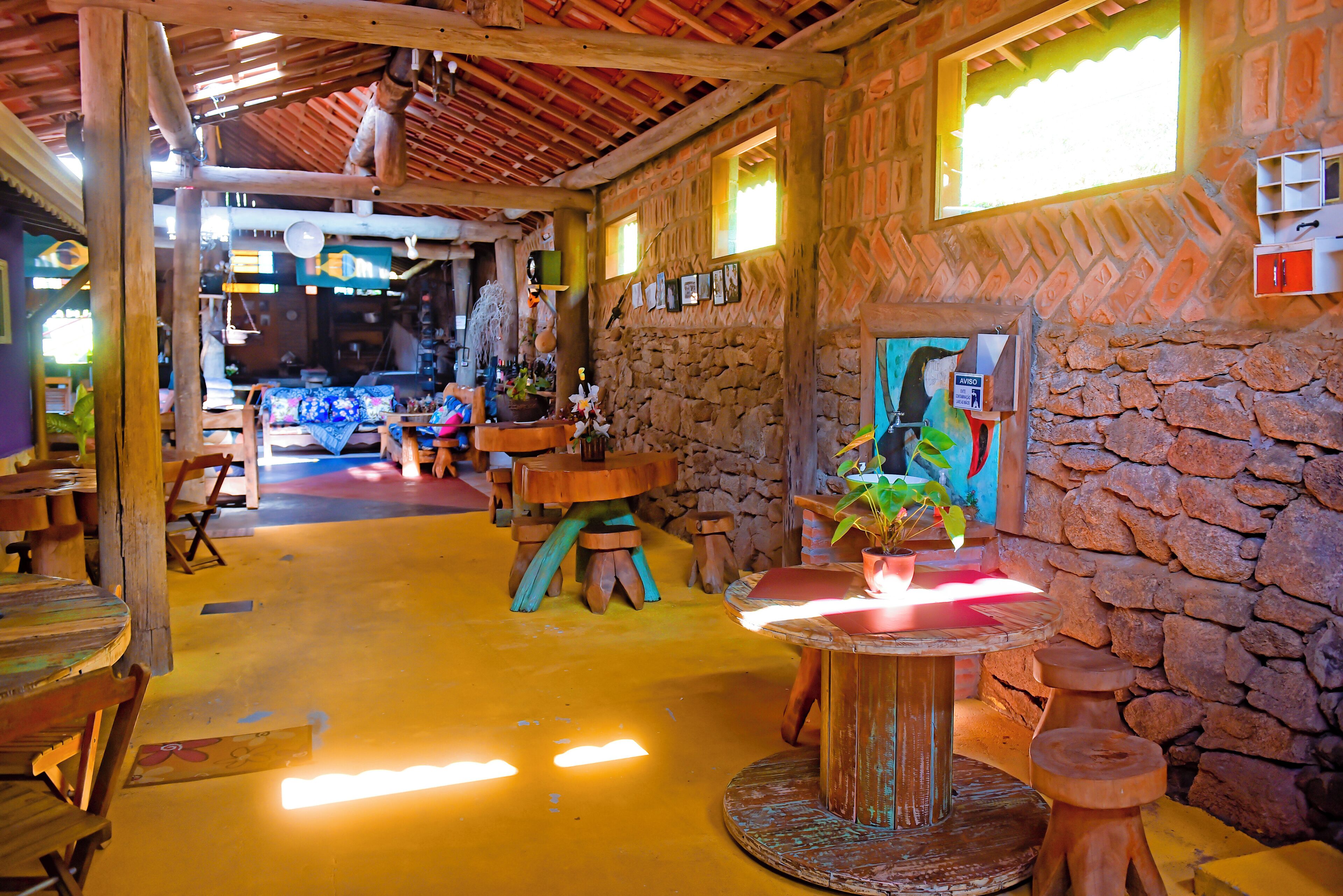 A rustic interior with wooden furniture, a stone wall, and a window with natural light.