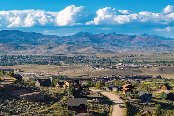 A residential area with houses, a road, and mountains in the background.