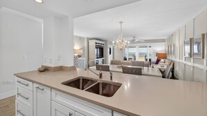 Une cuisine moderne dotée d’un grand îlot central, d’appareils électroménagers intégrés et d’un coin repas offrant une vue agréable.