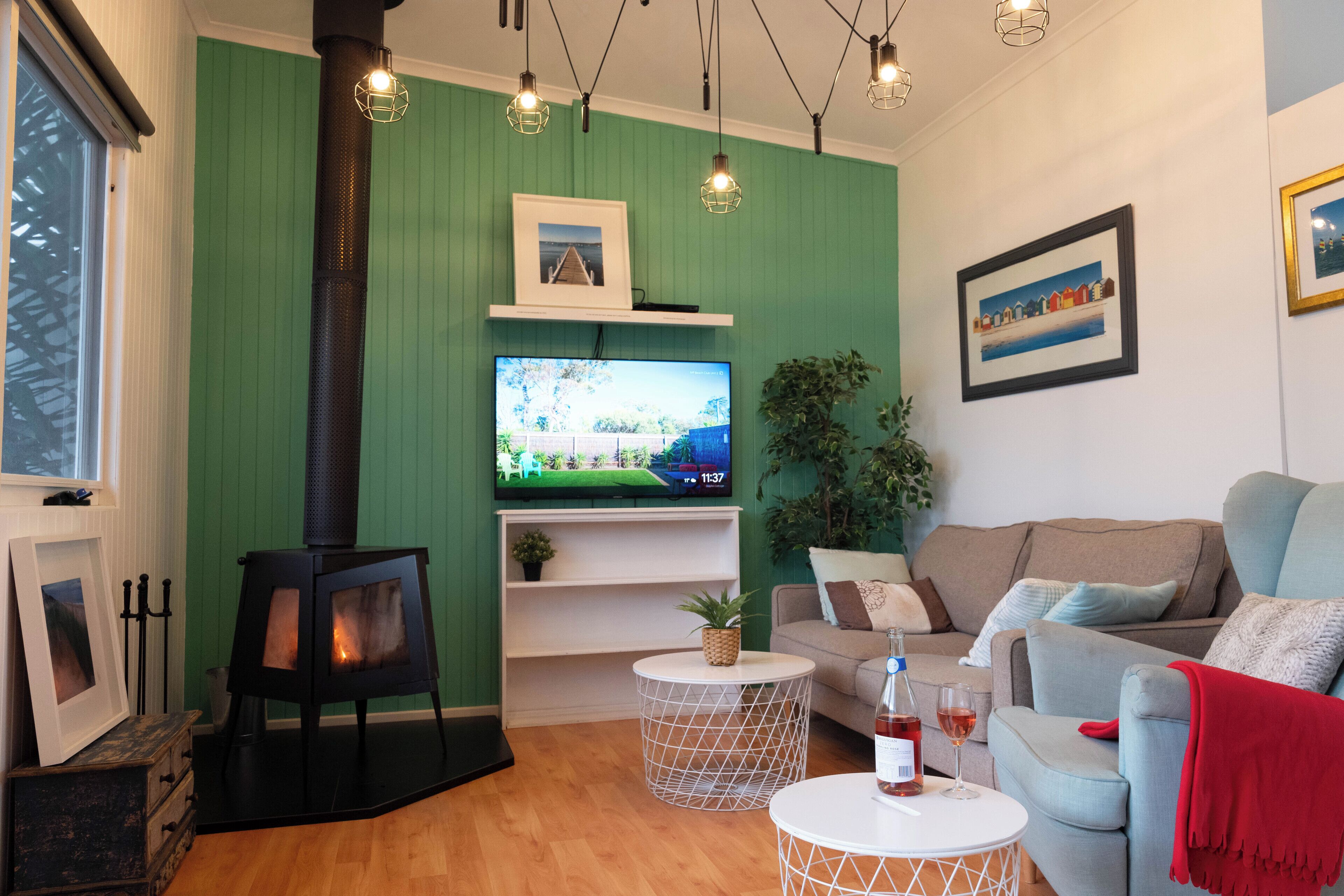 A cozy living room with a wood-burning stove, a television, and a comfortable sofa.