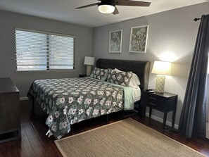 A bedroom with a bed, bedside tables, a ceiling fan, and a window with blinds. - Comfy Townhome Retreat (Modesto)