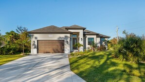 A modern two-story house with a garage, a well-maintained lawn, and a clear sky. - New 3BR , Near Myakka River, Boca Grande + Beach (Port Charlotte)