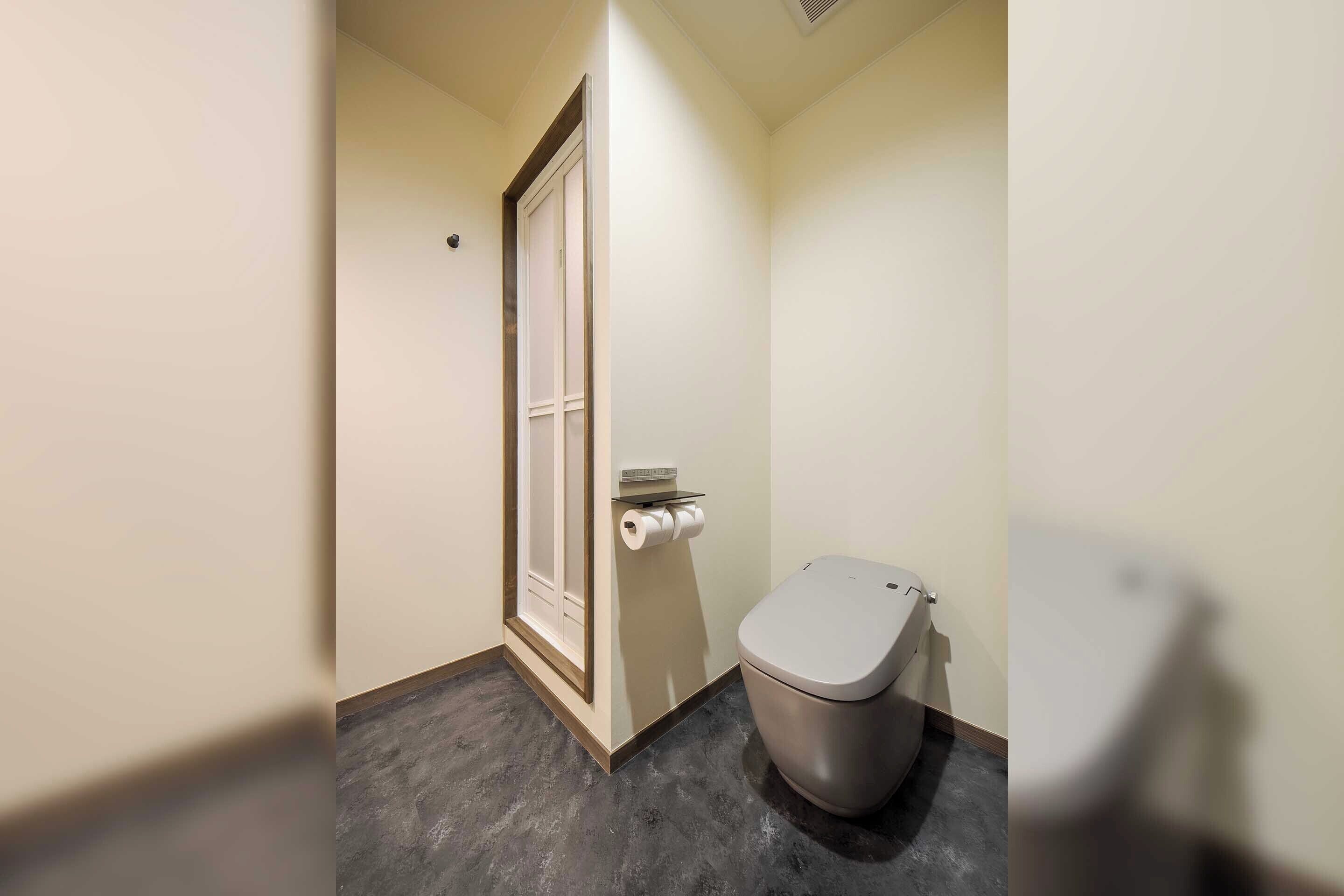 Een kleine, smalle badkamer met toilet en deur.