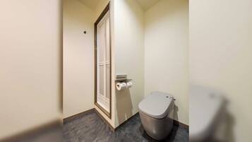 Een kleine, smalle badkamer met toilet en deur.