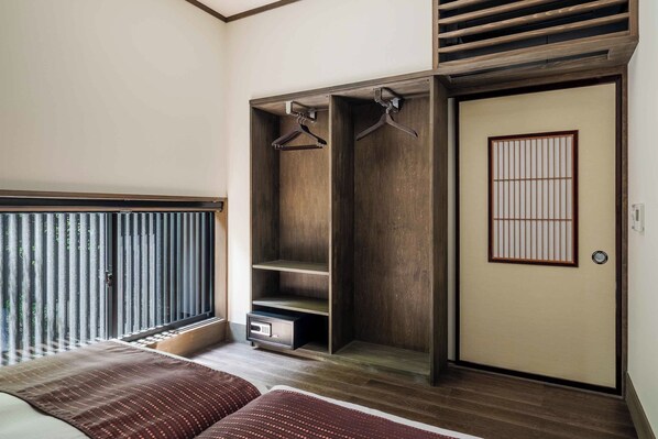 Un dormitorio con una cama grande, un armario con espacio para colgar y una puerta corredera.