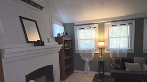 Una sala de estar con chimenea, un sofá y un tapete estampado.