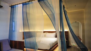 Ein Schlafzimmer mit einem Bett, einem Nachttisch, einem Sofa und einem Sessel.