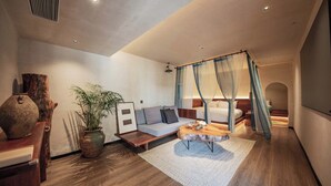 Ein modernes Schlafzimmer mit Himmelsbett, einer Couch, einem Couchtisch und einer großen Pflanze.