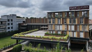 A modern hotel with a flat roof terrace, multiple floors, and a sign indicating it is the Cubix Hotel. - Cubix Hotel (Hubli)
