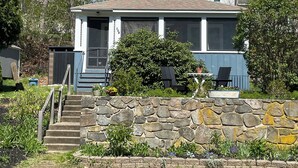 A house with a stone wall, a front porch, and a small garden. - Beach garden cottage with AC in charming Ogunquit (Ogunquit)